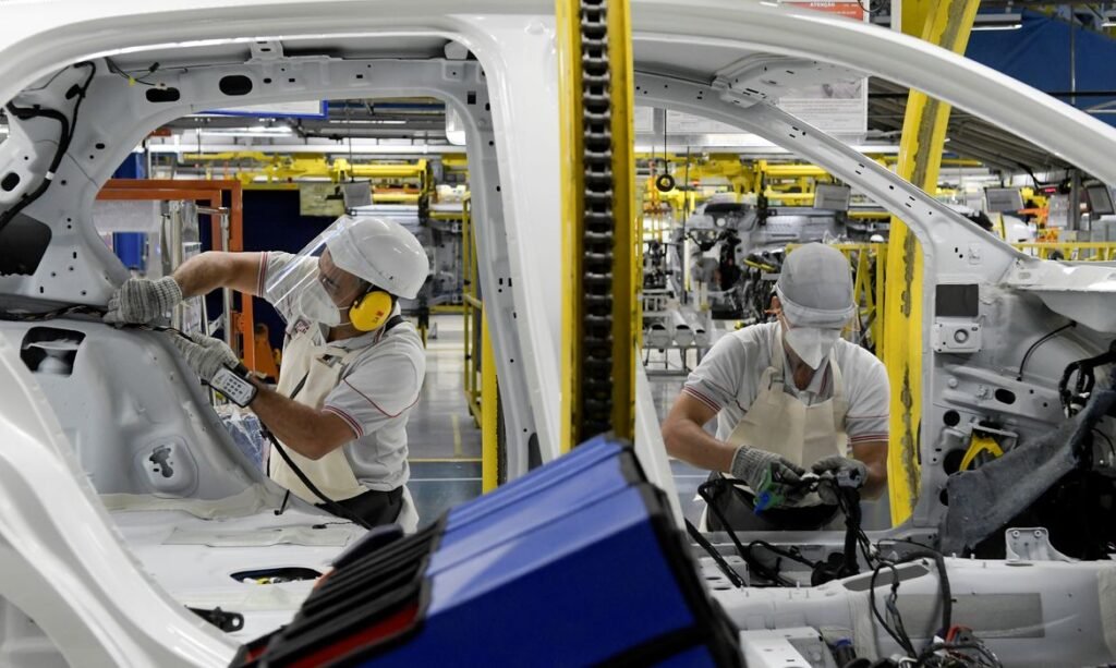 Os trabalhadores da montadora Fiat Chrysler Automobiles constroem um modelo Argo 2020, em meio à disseminação da doença por coronavírus (COVID-19), na fábrica de montagem em Betim