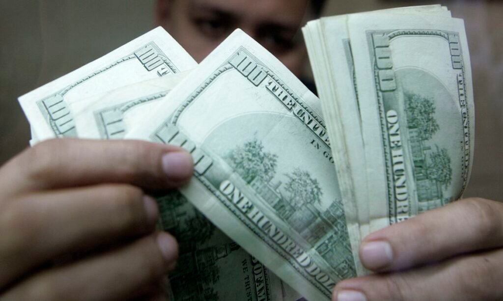 Funcionário de casa de câmbio verifica notas de dólar em Manila 7 de agosto de 2009 REUTERS/Cheryl Ravelo