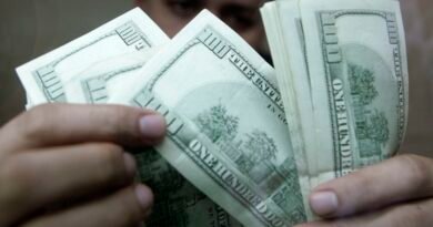 Funcionário de casa de câmbio verifica notas de dólar em Manila 7 de agosto de 2009 REUTERS/Cheryl Ravelo