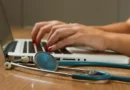 Médica digita no computador, tendo seu estetoscópio ao lado. Foto: National Cancer Institute/Unsplash