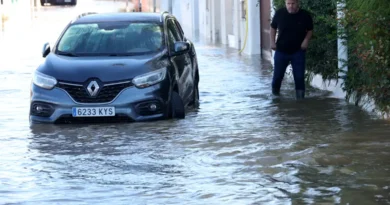 A man walks in a flooded street, following torrential rain, in Oliva, Valencia province, Spain, October 20, 2026. REUTERS/Eva Manez
